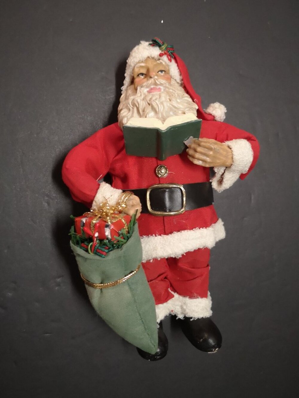 Sabre 7.5" Tall Resin Santa holding a Book & Christmas Gift Bag Material Suit
